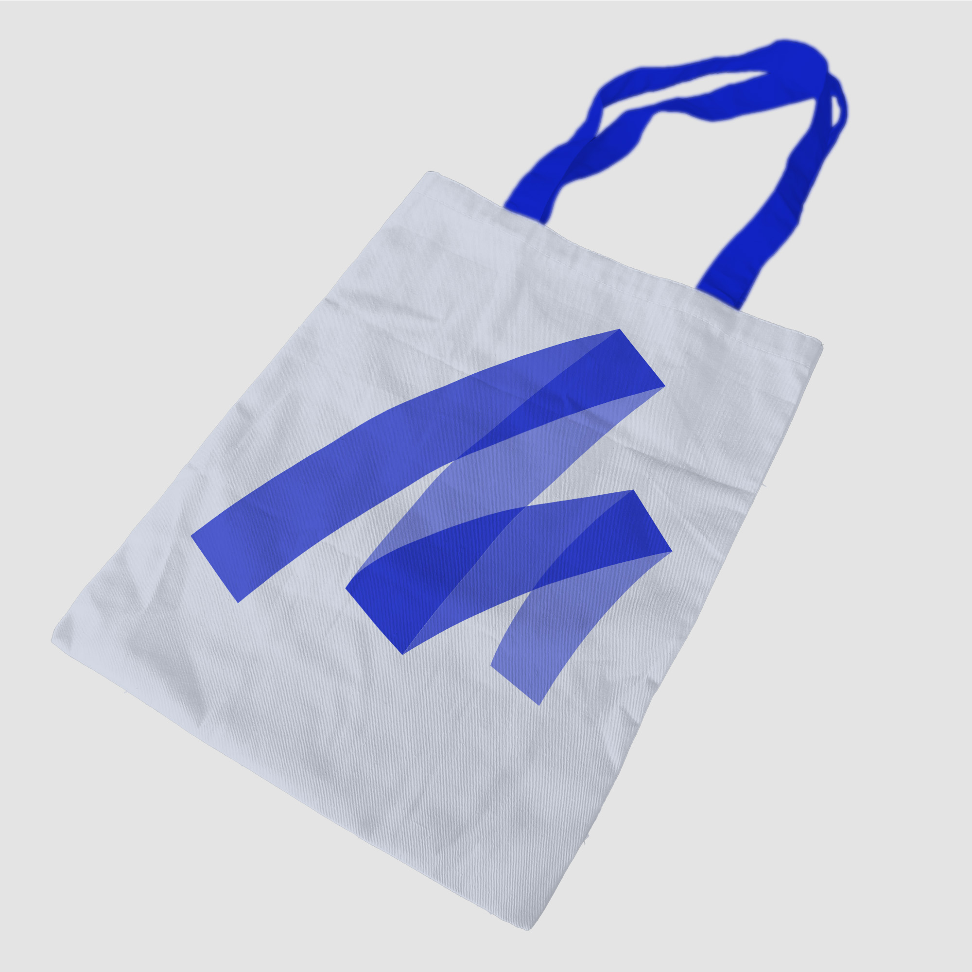 Mockup van een canvas draagtas van Marker Media met een opvallend blauw logo op een witte achtergrond. De tas heeft blauwe handvatten en toont een strak, modern ontwerp, ideaal voor het promoten van het merk.