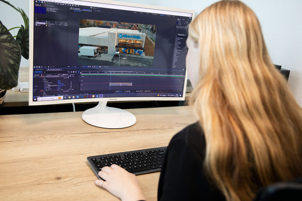 Grafisch ontwerper bij Marker Media werkt aan videomontage en animatie op een desktopcomputer.